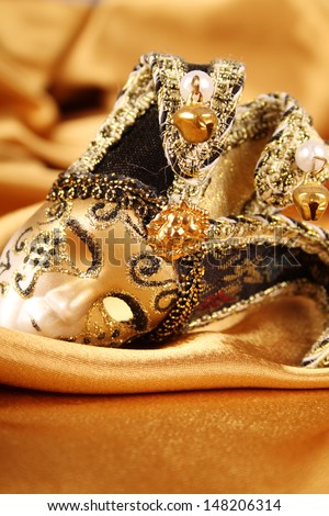 Carnival mask lying on a yellow silk