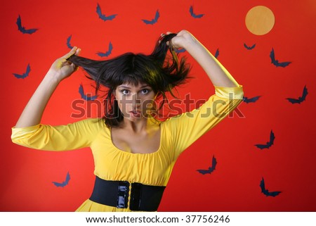 Girl in horror. Hands holding his head. Against the background of bats and the moon