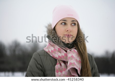 Beautiful brunetka winter on the street looks into the distance and laughs