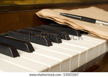 Brown wooden piano with music books and manual