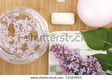 On the wooden table flowers, cream, soap, a brush for cleaning person