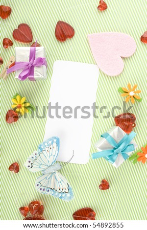 Blank note cards on a green background with butterflies, hearts and gifts