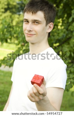 Gift for you. Red gift box in the hands of young men