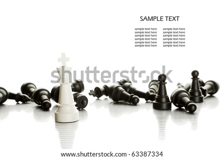 White King in the foreground against a background of black army chips. White King in the foreground against a background of black army chips.