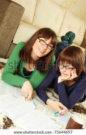 Two girls young student in a room on the floor, and learn to smile