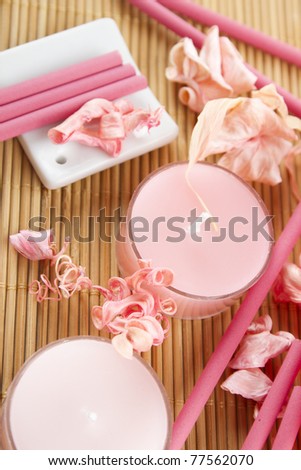Spa treatment in bright pink and white palette, petals, candles, and arotatizirovannye sticks on a wooden bamboo rug