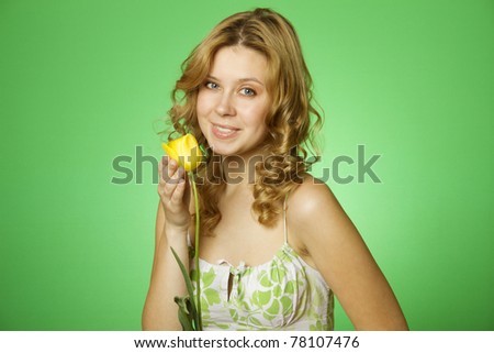 HappyClose up on a green background Happy young woman hugging a yellow tulip. Young Woman Hugging Flower