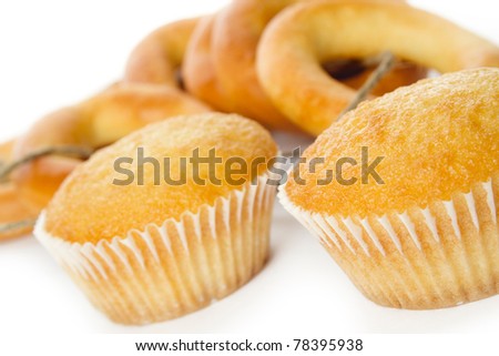 Two cupcake in the foreground to the background of donuts on the rope. Isolated on white background