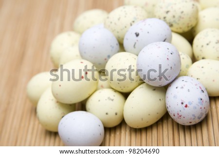 Chocolate Easter eggs are scattered on the wooden surface. background