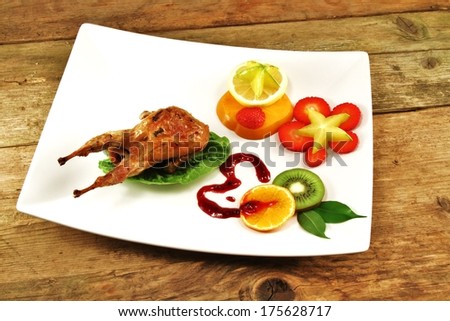 Quail on a bed of lettuce with exotic fruit set