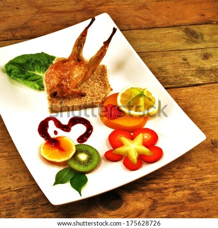 Quail on a bed of bread with exotic fruit set