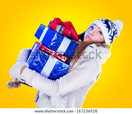 Christmas Woman. Beautiful New Year and Christmas Gift Holiday Hairstyle and Make up. Beauty Girl with Colorful Makeup, Hair, Gift and Accessories. Happy and funny Woman. Emotions. Yellow background