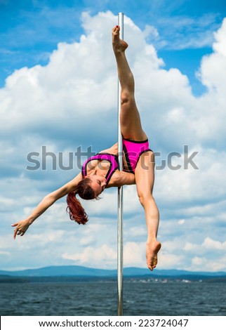 Young sexy woman exercise pole dance