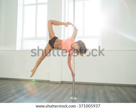 Young sexy pole dance woman. Bright white colors.