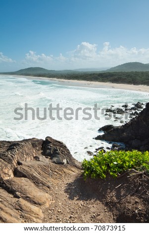 australian seascape during the day with cliff face in foreground (Cabarita Beach,NSW)