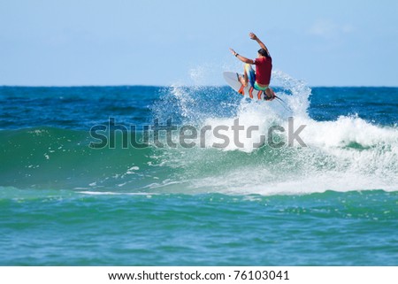 surfer jumps over the big wave with a splash