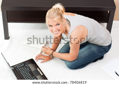 young smiling attractive woman works on her laptop