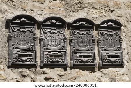 Four aged metal mailboxes in Volterra waiting for delivery