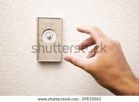 Hand reaches to thermostat with missing knob