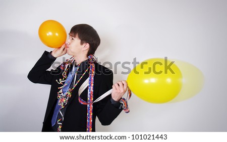 Portrait of young man blowing a balloon over white background