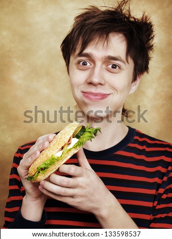 The happy young man with a big hamburger