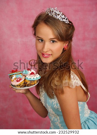The beautiful girl in a crown with a dessert in hands
