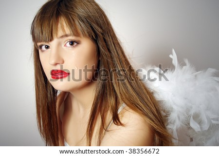 Portrait of the crying pretty girl with wings of an angel