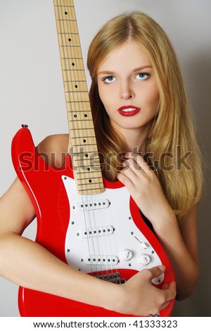 stock photo Beautiful sexy guitar woman on gray background looking upwards