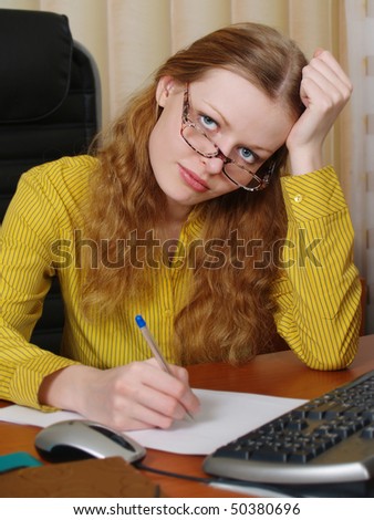 Young, beautiful businesswoman sits at a table and thinks