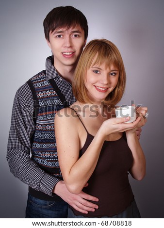 Portrait of happy young woman and man with cup of tea  smiling together
