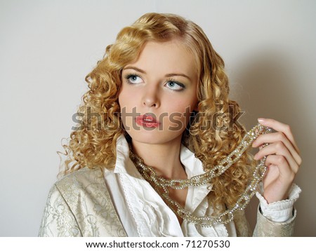 Fashion  beautiful girl with blonde long hair posing on light background