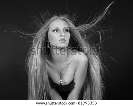 Portrait of the beautiful girl with the long fair hair blown by a wind