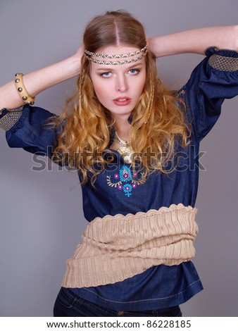 The beautiful young woman dressed in folklore style with a knitted belt