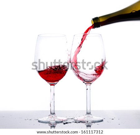 Red wine pouring down from a bottle isolated on white