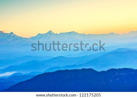 early morning scene at mountain with sun ray illuminating layers of hills