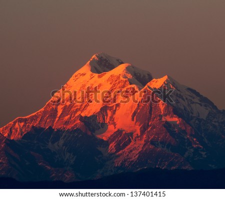 beam of sun light illuminating mountain with three peaks in Himalaya
