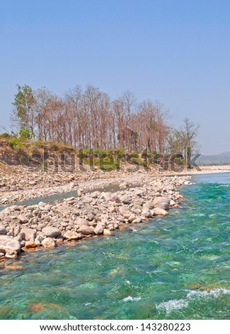 image of river with boulders and clear blue water in himalaya
