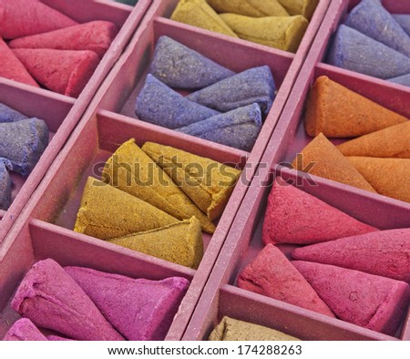 close up of conical Incense of different colors arranged in a  box