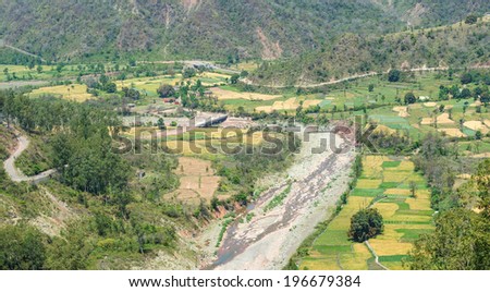 mountain valley with dry stream and cultivated farms In Indian Himalaya