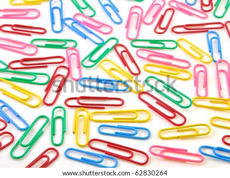 close op of colorful paper clips scattered on white background
