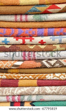 close up of stacked  folded colorful carpets