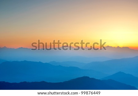 wide shot of mountain valley with rising sun