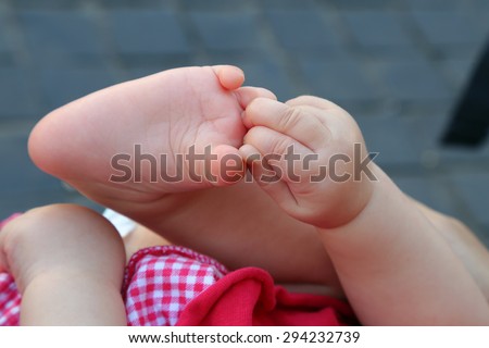Newborn plays with hands and feet