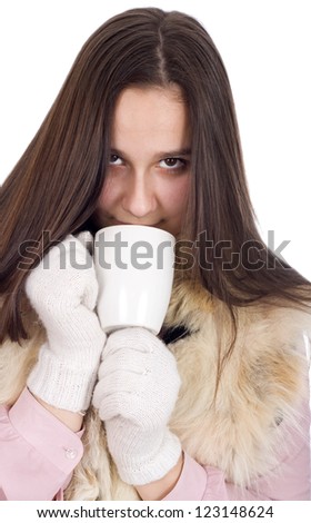 Woman in winter clothes and white gloves, drinking tea and warmed