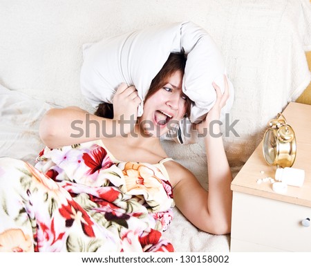 woman with a pillow on his head in horror that he could not sleep