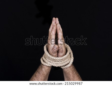 Men\'s hands tied a rope isolated on a black background