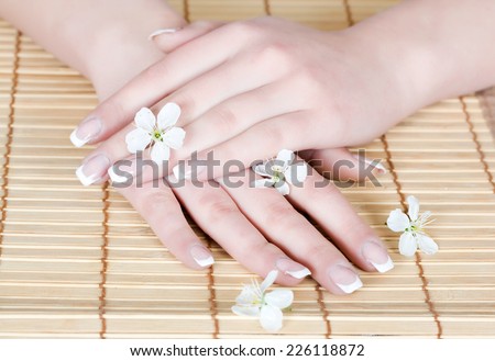 Beautiful french manicure with little flowers on a bamboo towel