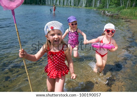 Three little cute girls running on coast together