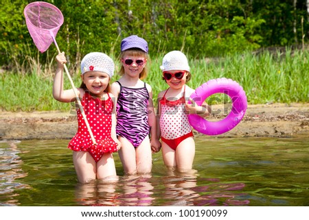 Three little cute girls go in water together Three little cute girls go in water together