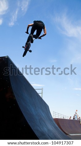 young  boy is jumping with his BMX Bike at the skate park